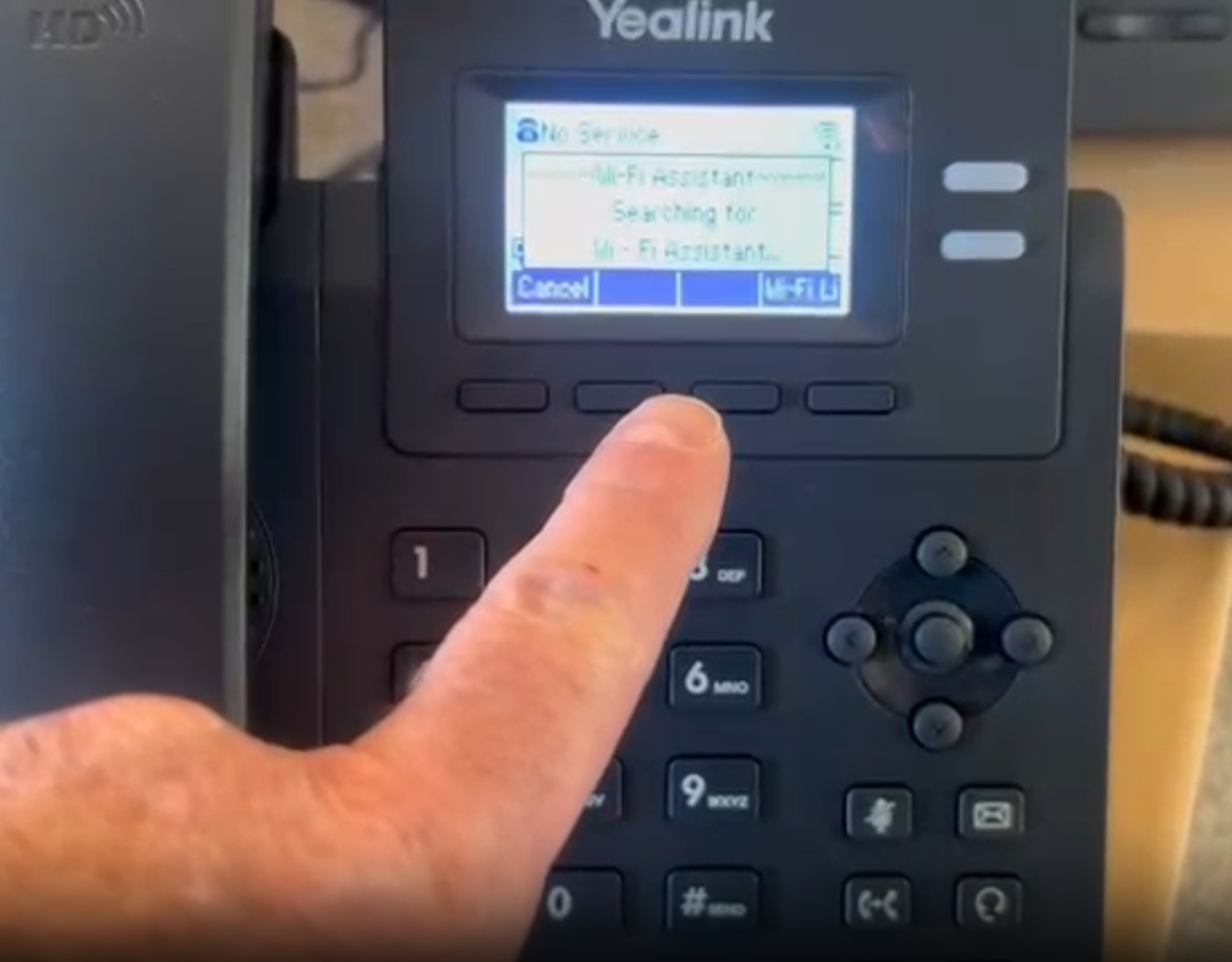 Yealink T31W VoIP desk phone showing WiFi Assistant searching for networks